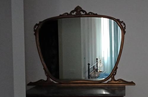 a mirror on a shelf in a room at Villa Giove Rooms in Prato