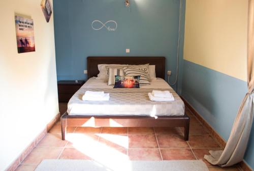 a bedroom with a bed with a blue wall at The SURF hOuSe @ Keros Beach , Kalliopi in Kalliópi
