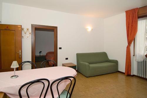 a room with a table and a green chair at Camping Hotel Au Lac De Como in Sorico