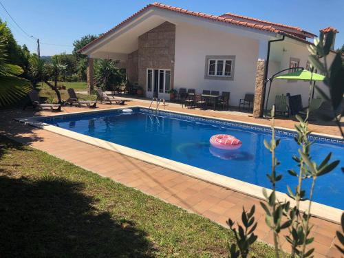 a swimming pool in front of a house at The Oak´S Wolf-Country House in Fafe