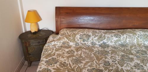 a bed with a wooden headboard and a lamp on a table at Villa Punta Salina in Palm-Eagle Beach