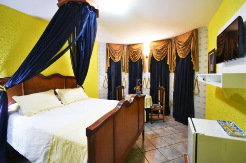 a bedroom with a bed with blue drapes at Pousada Estalagem de Brotas in Brotas