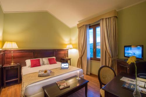 a bedroom with a bed and a desk and a television at Country Hotel & Resort I Calanchi in Ripatransone