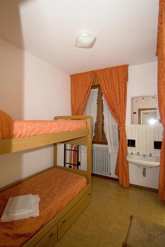 a bedroom with two bunk beds and a sink at Camping Hotel Au Lac De Como in Sorico
