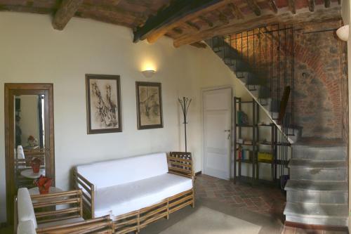 a living room with a bed and a staircase at Agriturismo la Torre in Bagni di Lucca