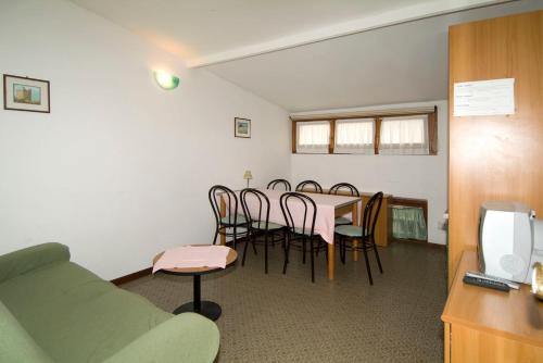a room with a table and chairs and a couch at Camping Hotel Au Lac De Como in Sorico