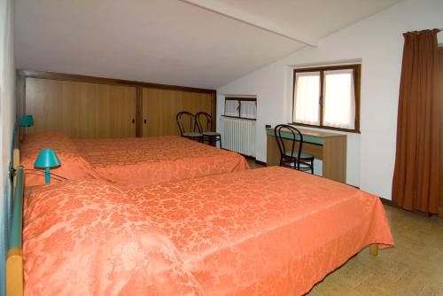 a hotel room with two beds and a desk at Camping Hotel Au Lac De Como in Sorico