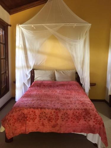 a bedroom with a bed with a canopy at Vila Sofia chalès in Morro de São Paulo