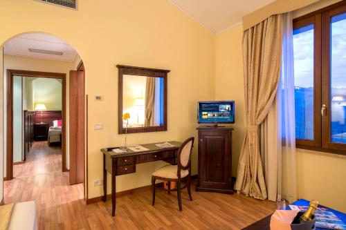 a room with a desk and a television in a room at Country Hotel & Resort I Calanchi in Ripatransone