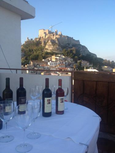 a table with wine glasses and a castle on a hill at Hotel Mediterraneo in Roccella Ionica