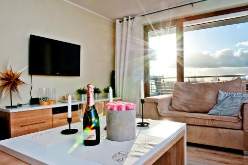 a living room with a bottle of wine on a table at BlueApart Apartamenty Na Klifie in Władysławowo