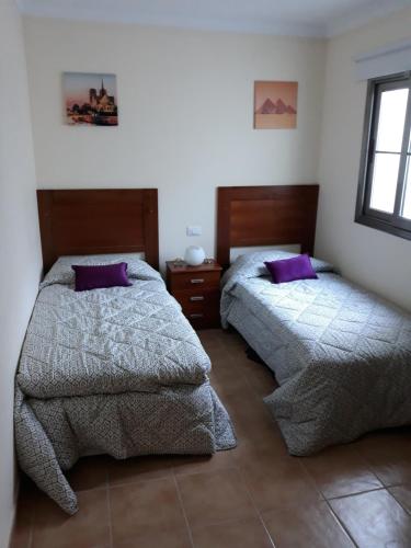 プエルトリコにあるTHE 69の紫色の枕が備わる客室内のベッド2台