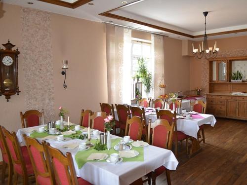 a dining room with tables and chairs and a clock at Hotel Gasthof Kruse in Nottuln