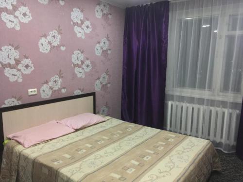 カザンにあるApartment on prospekt Fatykha Amirkhanaの紫の壁のベッドルーム1室(ベッド1台付)