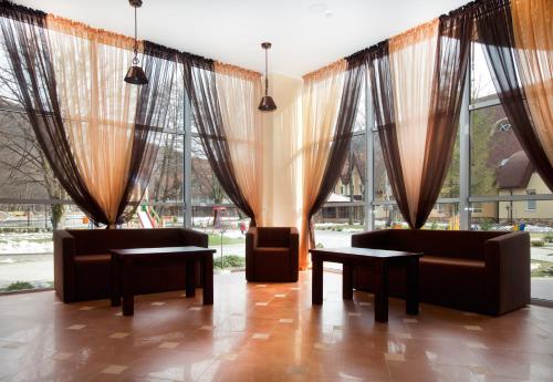 a lobby with couches and tables and windows at Belle Royalle in Lisarnya