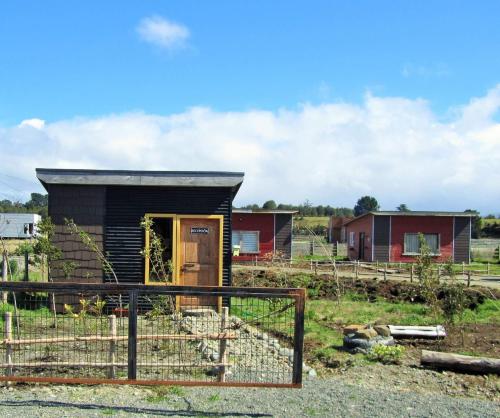 un pequeño edificio en un campo con casas en Cabañas Juan Jose, en Piruquina