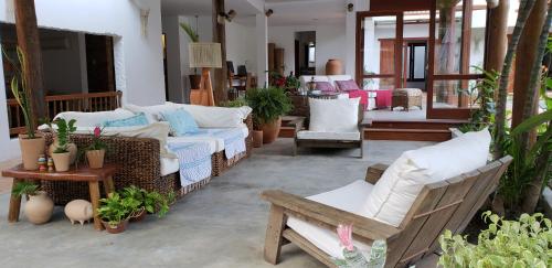 a living room with a couch and chairs and plants at A Casa de Gabriella in Itacaré