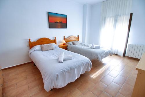 a bedroom with two beds with white sheets at CUENCALOFT EN SAN FELIPE in Cuenca