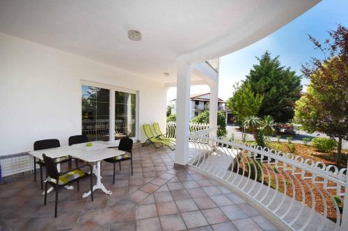 a patio with a table and chairs and a fence at Wish Apartments in Poreč