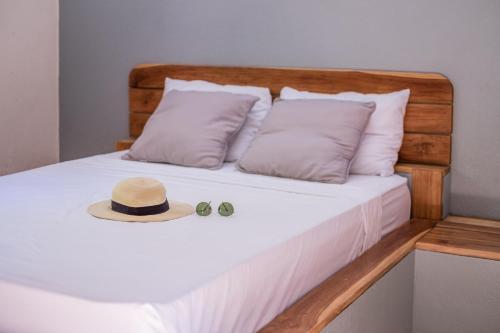 a bed with a hat and two glasses on it at Zula Inn Aparthotel in Santa Teresa Beach