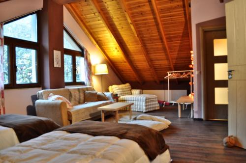 a bedroom with two beds and a living room with a couch at Chalet Coquelicot (Co-cli-co) relax in nature in Kalavrita