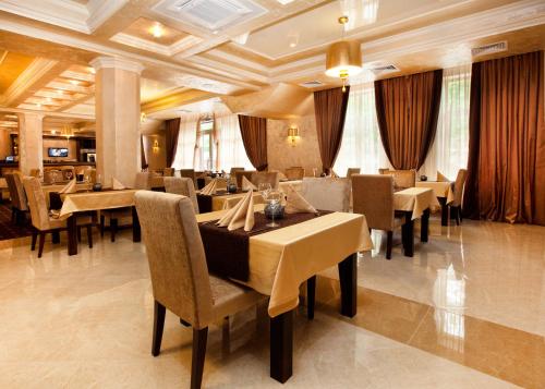 a restaurant with tables and chairs in a room at Belle Royalle in Lisarnya