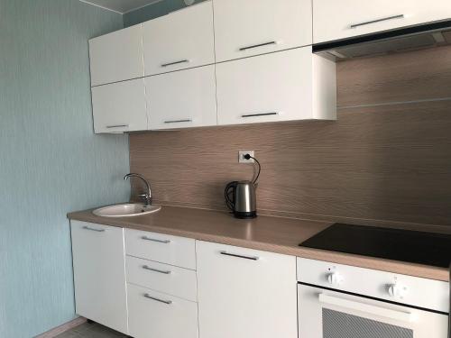 a kitchen with white cabinets and a sink at Парк Университет Exclusive МоМеНтАлЬнОе БЕСКОНТАКТНОЕ ЗАСЕЛЕНИЕ in Vladimir
