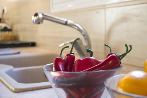 a bowl of peppers sitting on a counter next to a sink at The SURF hOuSe @ Keros Beach , Kalliopi in Kalliópi