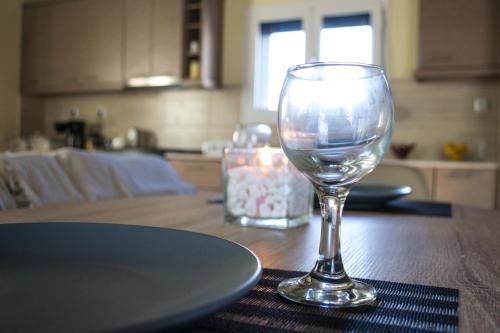 a wine glass sitting on top of a wooden table at The SURF hOuSe @ Keros Beach , Kalliopi in Kalliópi