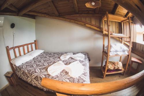 a bedroom with a bed and a spiral staircase at Pousada Pé na Areia in Garopaba