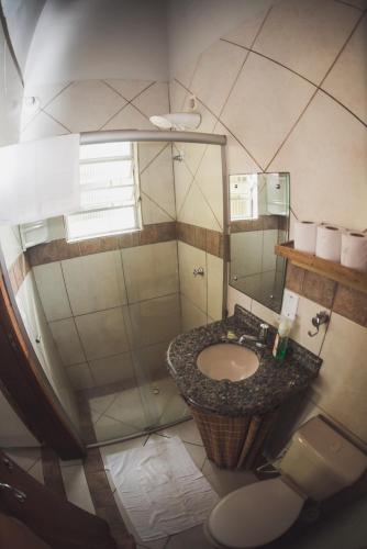 a bathroom with a sink and a mirror at Pousada Pé na Areia in Garopaba