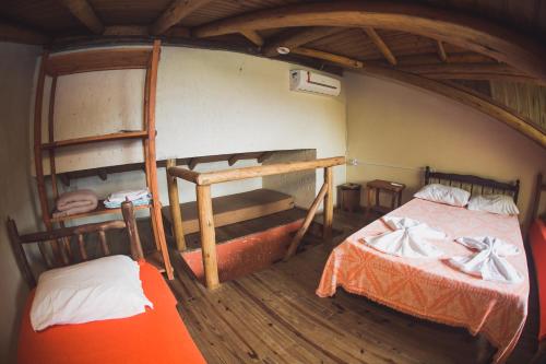 two bunk beds in a room with an attic at Pousada Pé na Areia in Garopaba