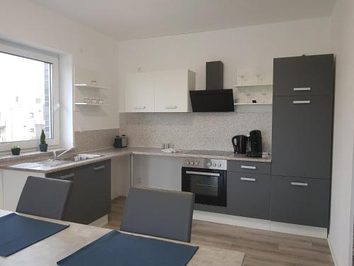 a kitchen with gray cabinets and a table and chairs at Appartement "Orchidee" in Hoya