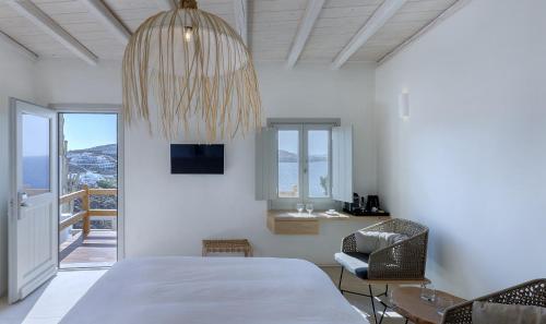 a bedroom with a bed and a chandelier at Legacy Suites in Mýkonos City