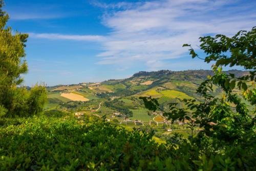a view of a green valley with houses on a hill at Country Hotel & Resort I Calanchi in Ripatransone