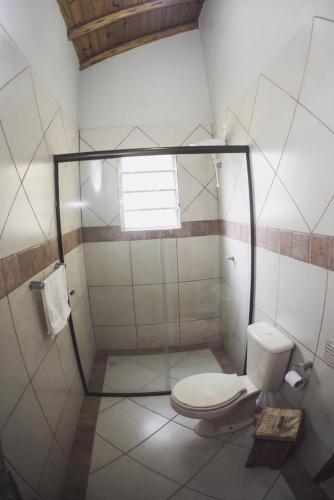 a bathroom with a toilet and a shower at Pousada Pé na Areia in Garopaba
