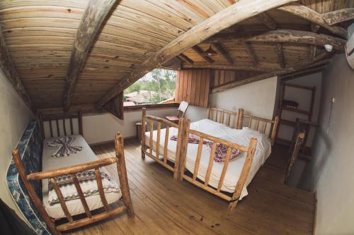 an attic bedroom with two beds and a wooden ceiling at Pousada Pé na Areia in Garopaba