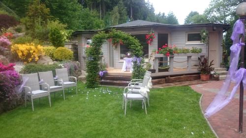 a garden with chairs and a woman in the background at Pension Ayky in Jablonec nad Nisou