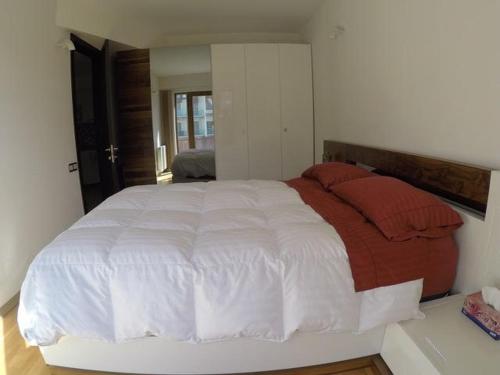 a bedroom with a large white bed with red pillows at Redco №1 Apartament Gondola LIft in Gudauri