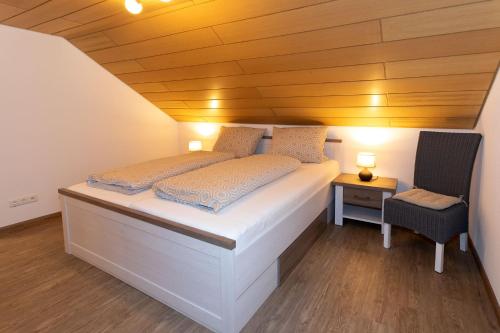 a bedroom with a white bed with a wooden ceiling at Gästezimmer - Ferienwohnung 2 - Brauhaus Dürr in Dorfprozelten