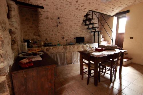 a kitchen with a table and chairs in a room at Residenza La Torre in Santo Stefano di Sessanio