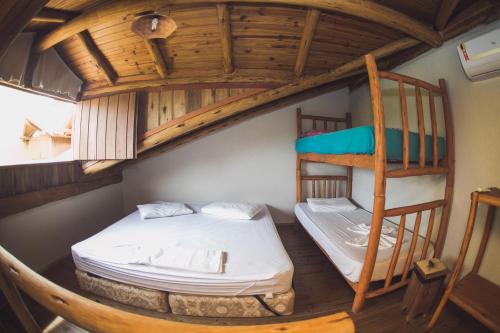 a room with two bunk beds and a ladder at Pousada Pé na Areia in Garopaba
