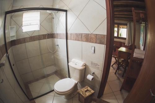 a small bathroom with a toilet and a shower at Pousada Pé na Areia in Garopaba