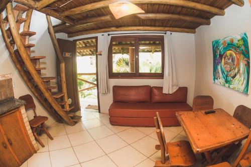 a living room with a couch and a table at Pousada Pé na Areia in Garopaba