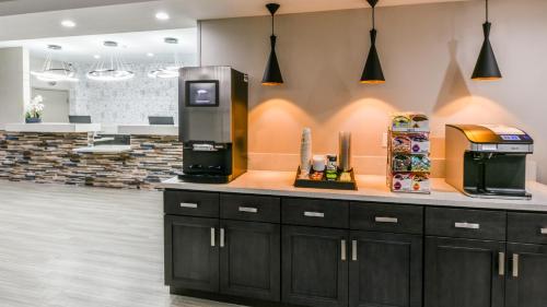 a kitchen with a refrigerator freezer next to a counter at Hollywood Inn Suites Hotel in Los Angeles