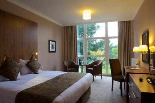 a hotel room with a bed and a desk and a window at Humber Royal Hotel in Grimsby