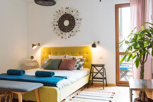 1 dormitorio con 1 cama con cabecero amarillo y espejo en Petite maison sur le boulevard en Bucarest