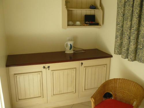 a small kitchen with a counter and a chair at Villa Jana Guesthouse in Pretoria