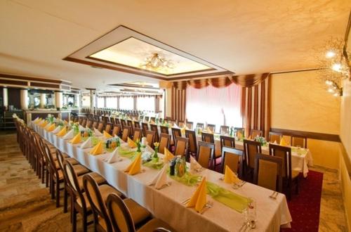a dining room with long tables and chairs in a building at Skalny Dworek in Nowy Targ