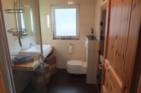 La salle de bains est pourvue d'un lavabo, de toilettes et d'une fenêtre. dans l'établissement Ferienhaus SEE Romantik mit Sauna und Whirlpool, à Zislow